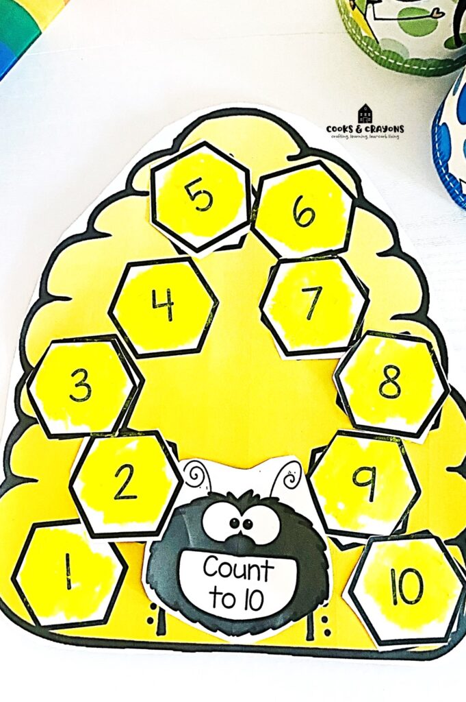 Teach kids to write the number before with this fun number sequencing activity. Download our free printable beehive template for engaging cut and paste math worksheets. Perfect for kindergarten math activities and number recognition practice!